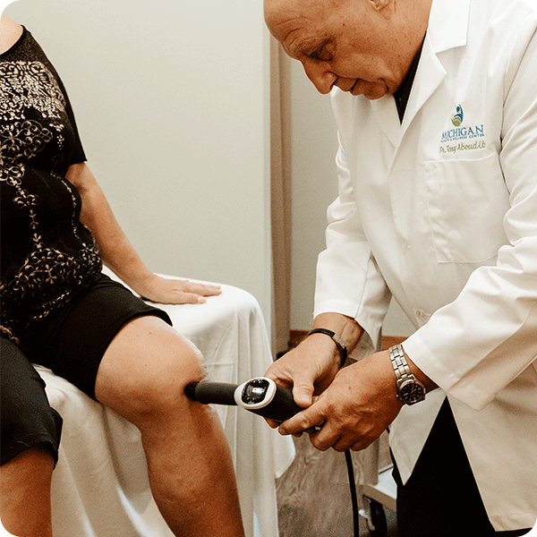 Doctor Tony performs shockwave therapy on female patient's knee